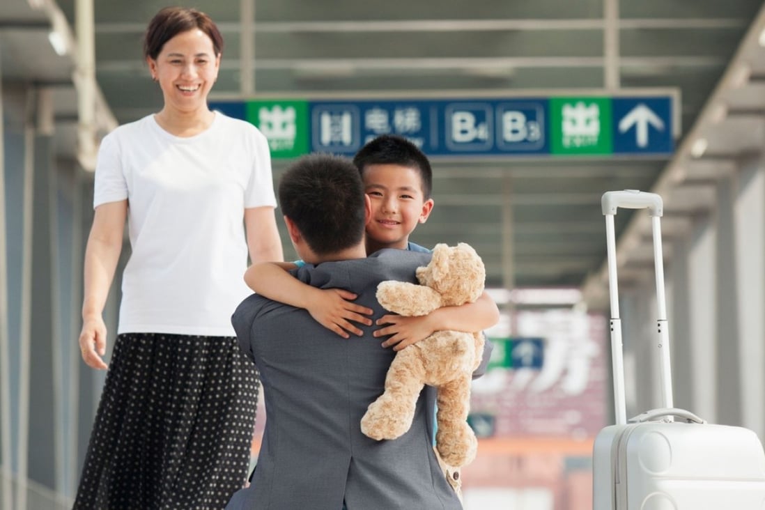 A Chinese boy greets his mum and dad after returning from a trip. Photo: Alamy