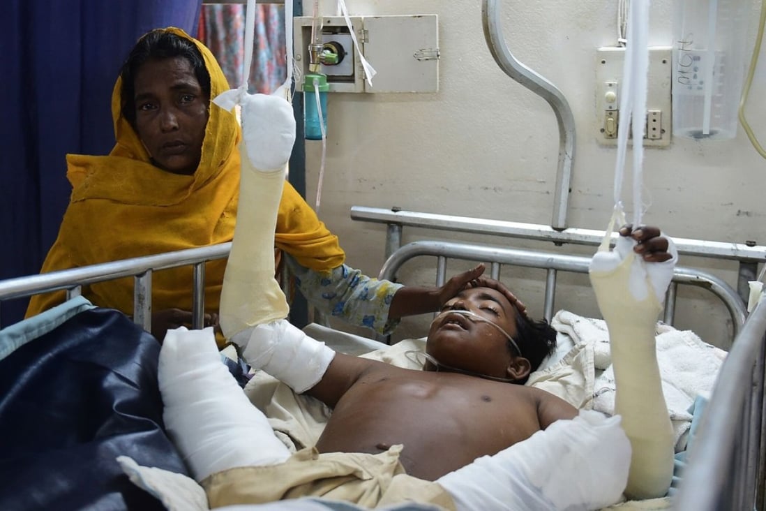 Rohingya Muslim refugee Rashida Begum stands next to her son Azizul Hoque, 15, as he is treated after being injured by a landmine while crossing from Myanmar to Bangladesh, at a hospital in Cox's Bazar. Photo: AFP