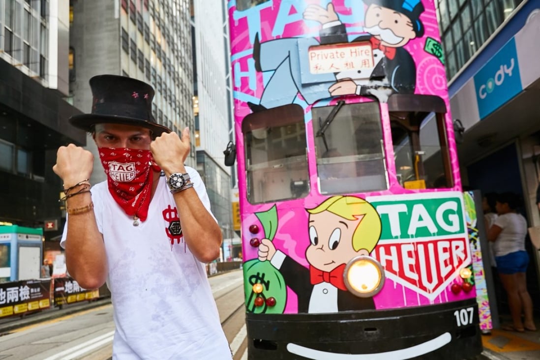 American street graffiti artist, who calls himself Alec Monopoly, beside his latest ‘canvas’ – a Hong Kong tram in Central.
