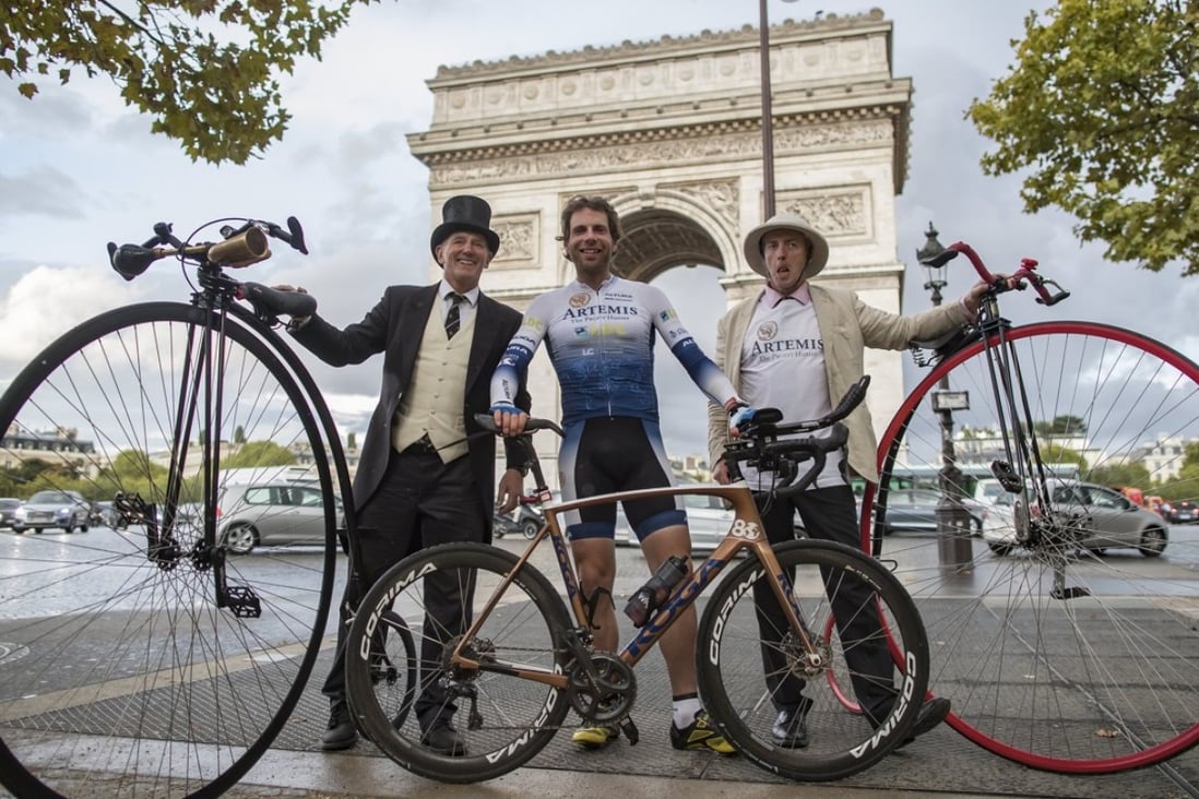 British athlete and adventurer Mark Beaumont poses with men with old bicycles as he arrives in Paris after cycling 29,000 kilometres around the world. Photo: EPA