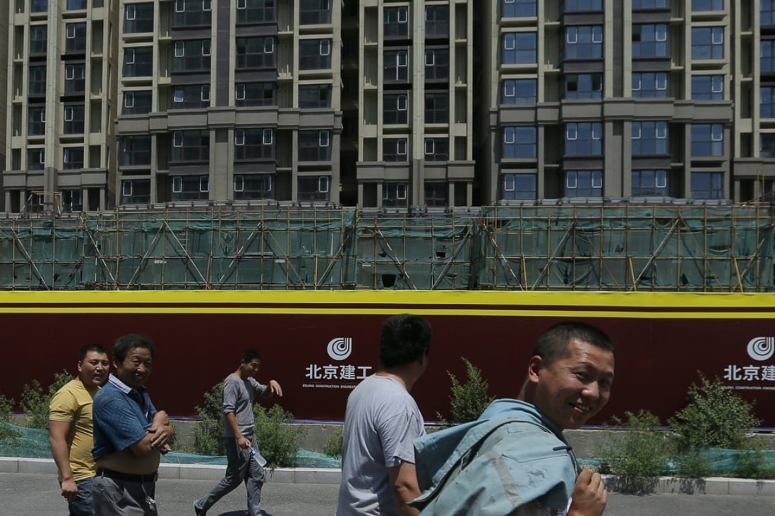 Migrant workers walk at a construction site in Beijing. The city is trying to persuade migrant workers to rent homes in exchange for better rights as it looks to stem the rising prices of property. Photo: EPA