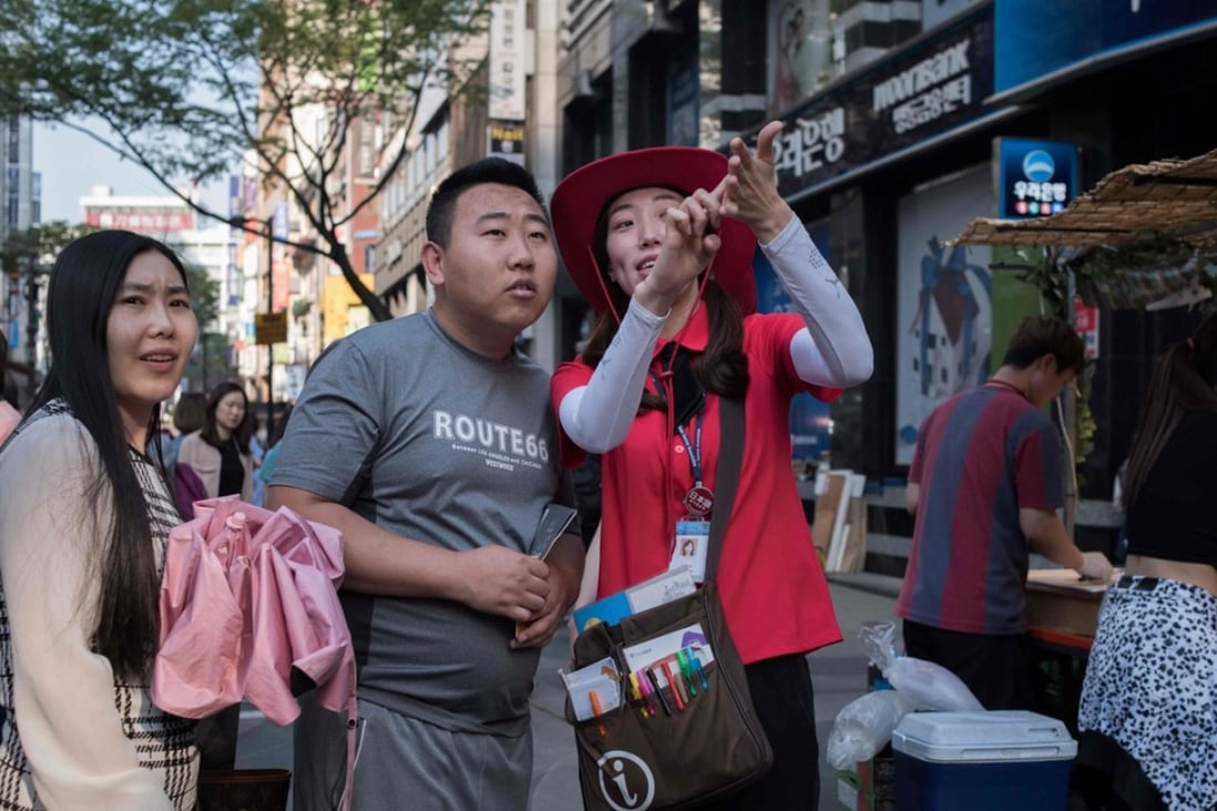 A South Korean guide directing tourists in the popular Myeongdong shopping area of Seoul. Less Chinese tourists are set to visit South Korea in the October Golden Week holiday period because of tensions between the two countries. Photo: AFP