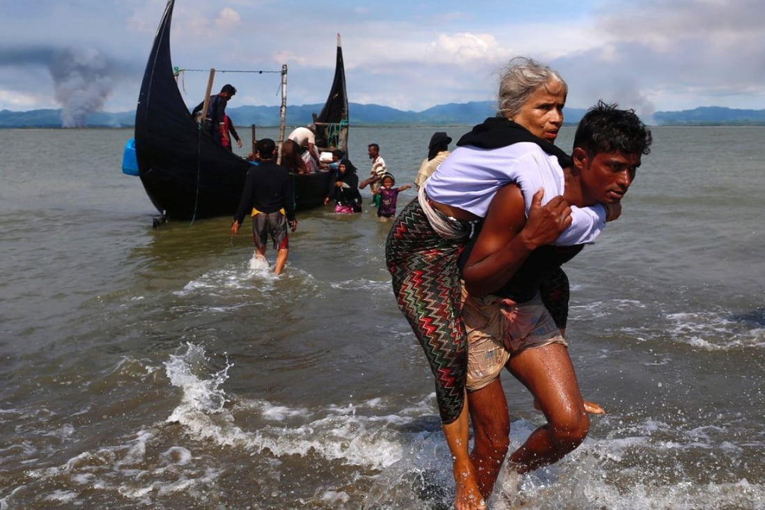 A Rohingya refugee, one of the hundreds of thousands displaced by the conflict in Rakhine, is carried to safety in Bangladesh. Photo: Reuters
