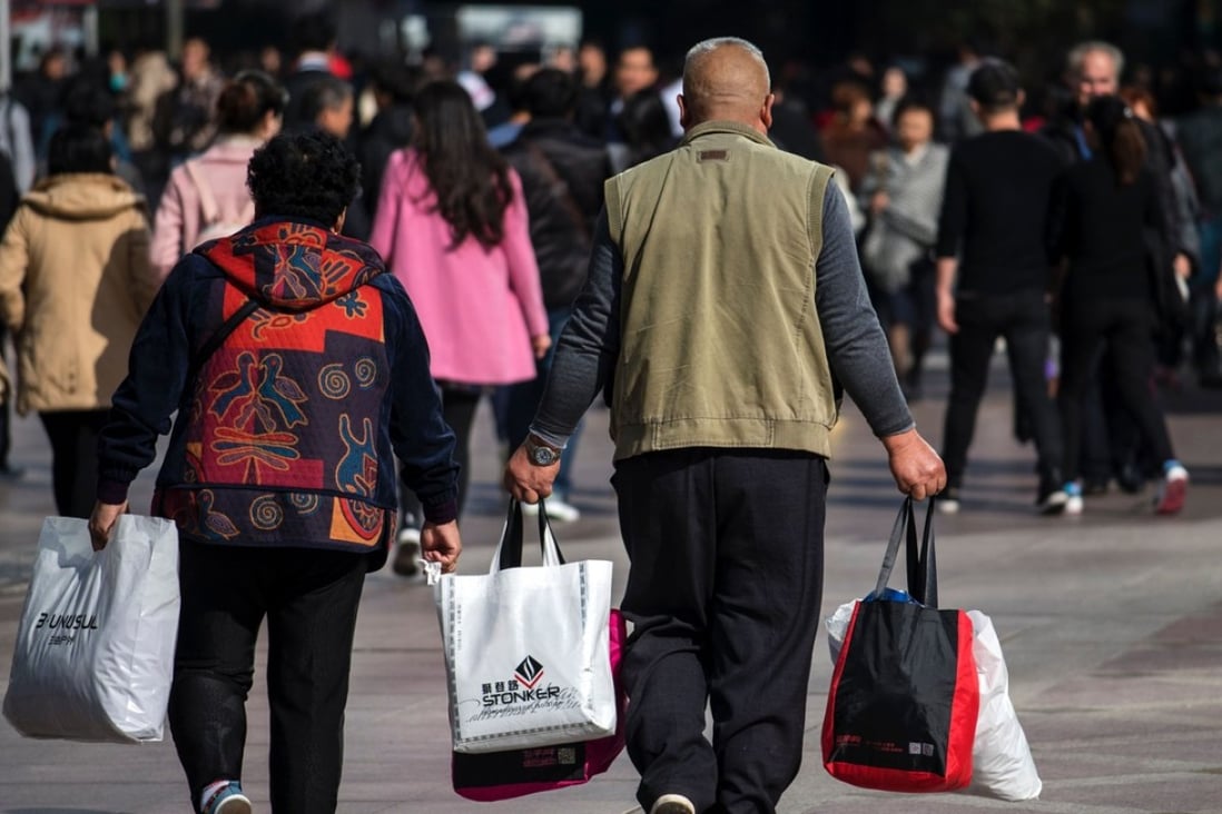 A couple carry bags along the main shopping street in Shanghai last November. More market rather than less is key to sustaining China’s economic growth in the long term. Photo: AFP