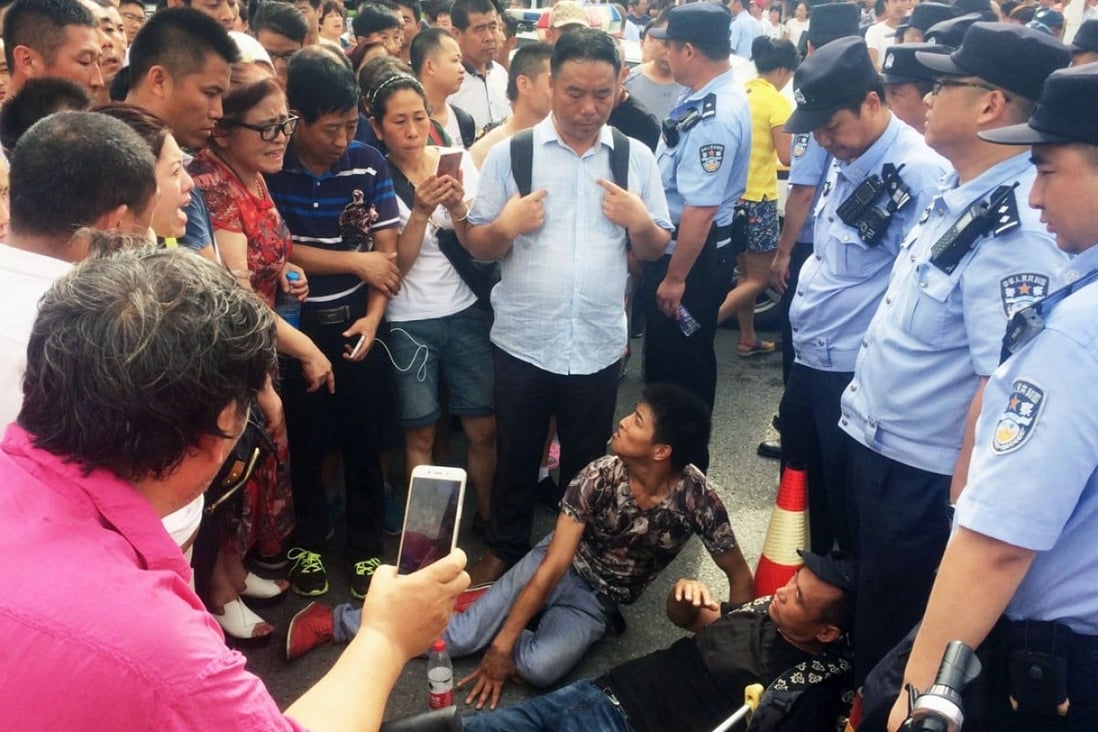 Protesters lie on the ground in Beijing on July 24 after police closed a road leading to a rally of people involved in Shanxinhuia, a suspected pyramid sales scheme. Photo: Kyodo
