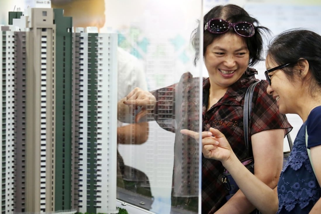 People watch the models of new Home Ownership Scheme flats during the first day's application at Hong Kong Housing Authority Customer Service Centre in Lok Fu. Photo: Nora Tam