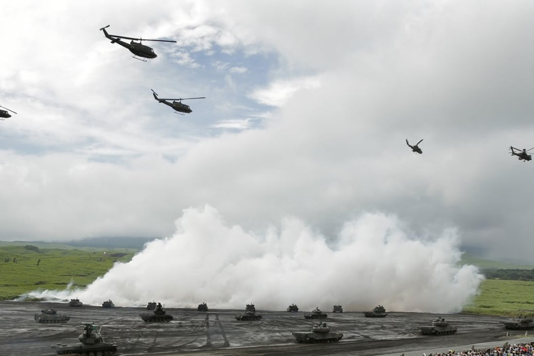 Japan Ground Self-Defence Force (JGSDF) helicopters and tanks move near a smoke screen during a live fire exercise at the foot of Mount Fuji. File photo: Bloomberg