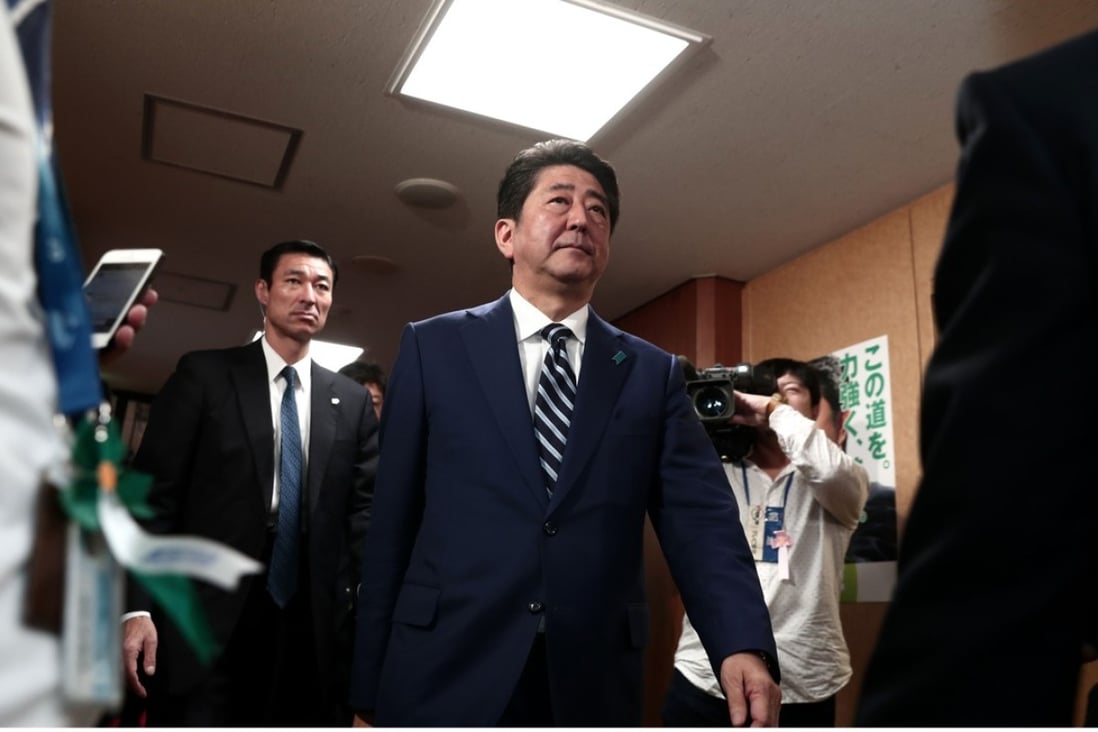 Japan’s Prime Minister Shinzo Abe arrives at the party headquarters to put rosettes by successful general election candidates’ names. Photo: AFP