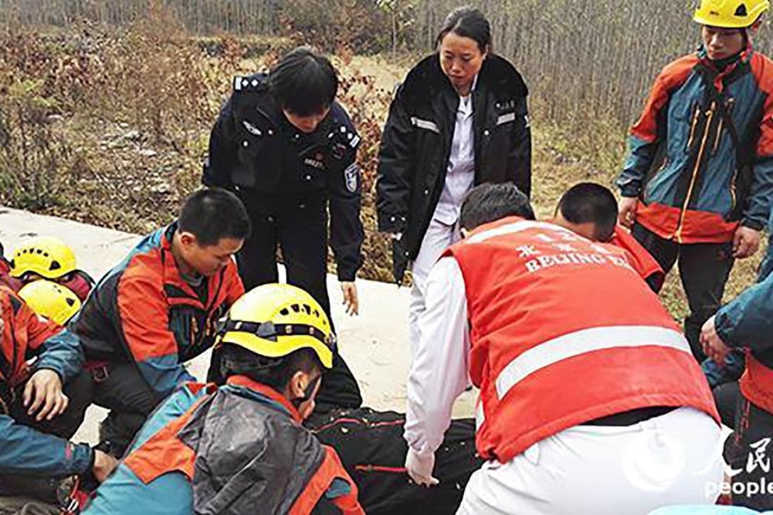 Rescuers attend to the family after they were trapped for 13 hours on one of the most dangerous sections of China’s Great Wall. Photo: People.cn