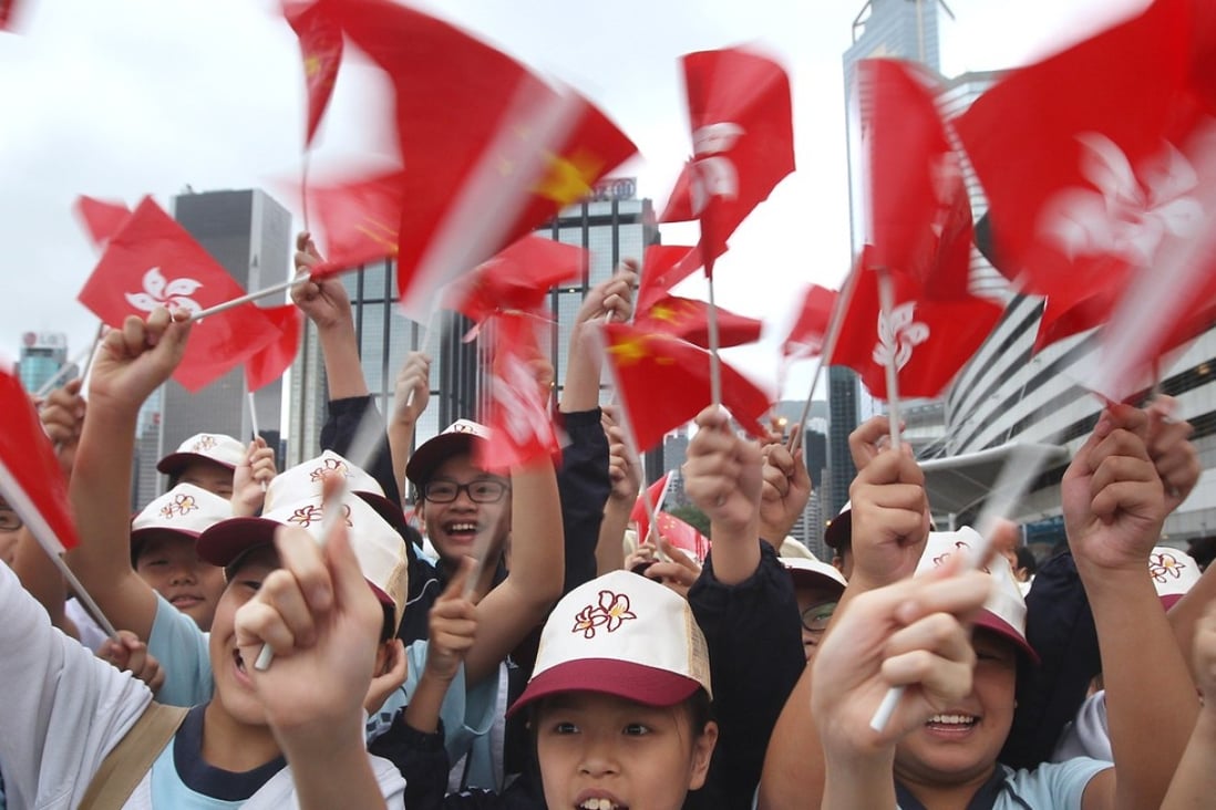 Pupils waving flags at a National Day ceremony at Golden Bauhinia Square in Wan Chai on October 1. Photo: Sam Tsang