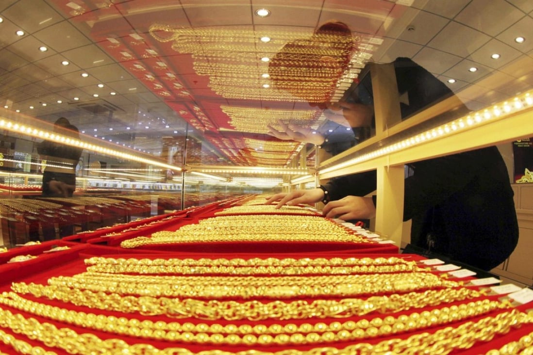 A sales assistant arranges gold necklaces at a store in Lianyungang, Jiangsu province in this January 23, 2014 file photo. Chinese firms could have locked up as much as 1,000 tonnes of gold in financing deals, an industry report said, indicating a big a slice of imports has been used to raise funds due to tight credit conditions, rather than to meet consumer demand. Photo: Reuters