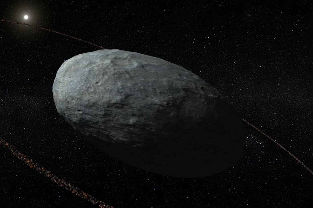 An artist’s rendering of the dwarf planet Haumea and its ring system, beyond Neptune. The discovery of a ring around an unassuming mini planet in our solar system debunks the theory that only giant planets have such features. Photo: AFP/Nature Publishing Group