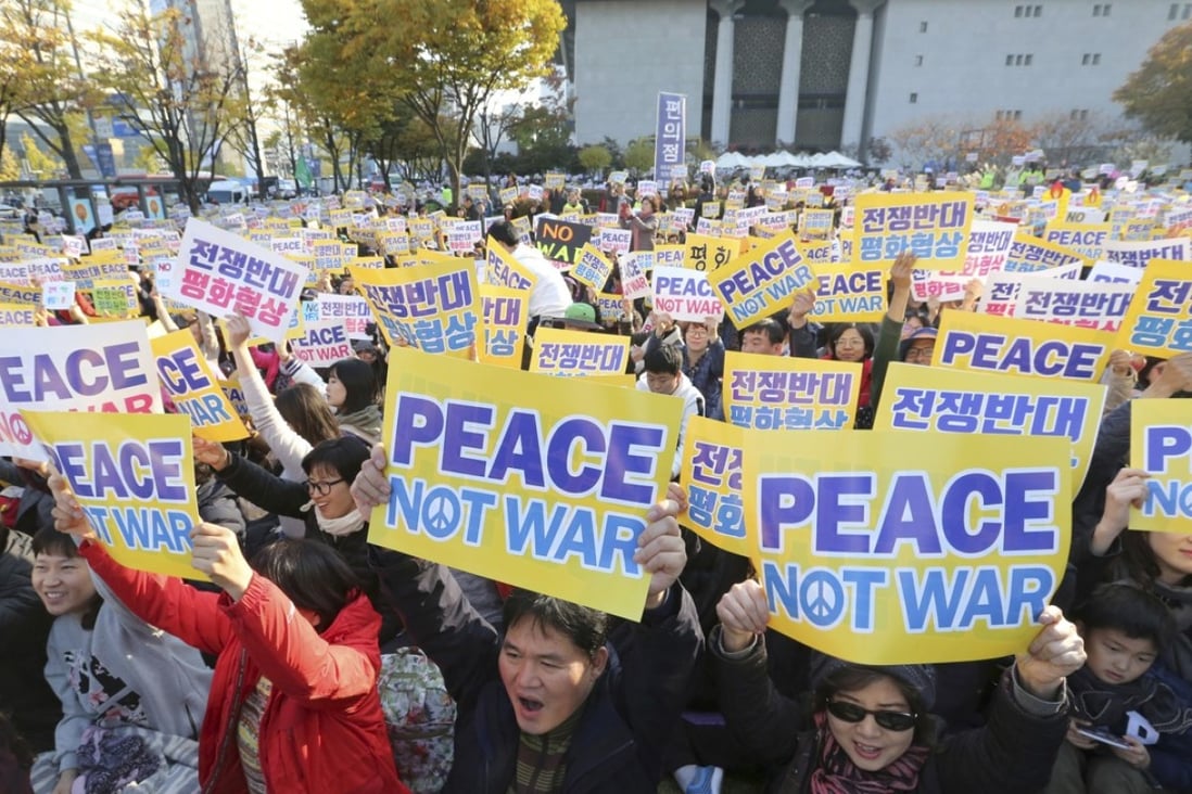 Anti-war protesters hold up placards near the US embassy in Seoul. Photo: AP