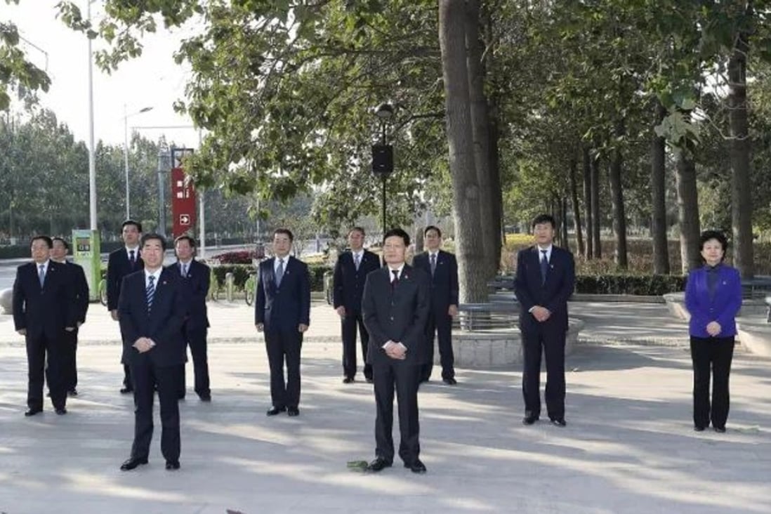 Henan officials gaze at a tree planted by Xi Jinping before they take their party oath. Photo: Handout