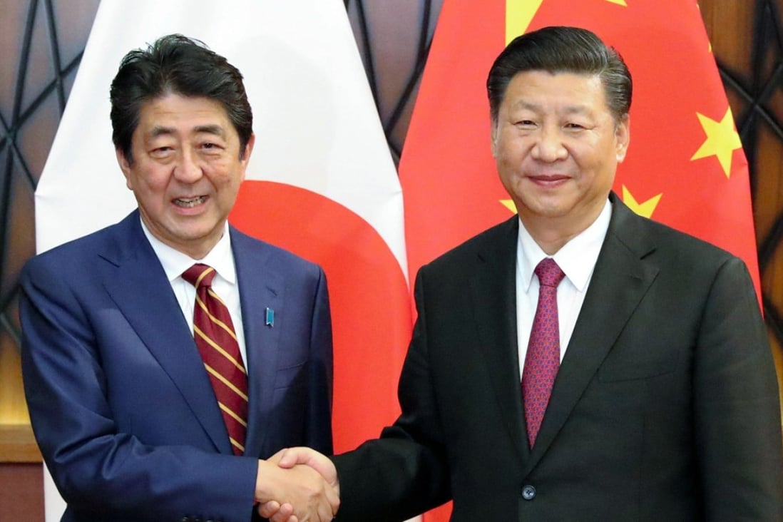 Chinese President Xi Jinping (right) shakes hands with Japanese Prime Minister Shinzo Abe in Da Nang, Vietnam, on Saturday. Xi said China and Japan should do more to improve ties. Photo: Kyodo