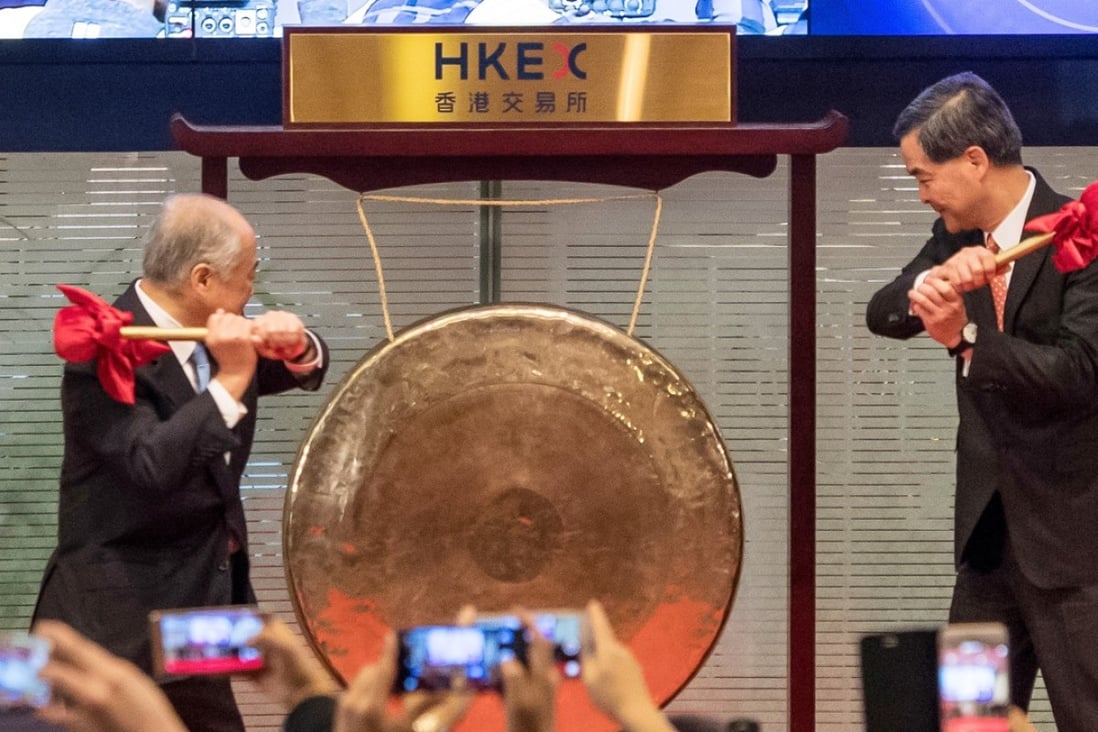 Chow Chung Kong, chairman of HKEX, left, and Leung Chun-ying, Hong Kong's then-chief executive, strike a gong at the launch ceremony of the Shenzhen-Hong Kong Stock Connect on December 5, 2016. Photo: Bloomberg