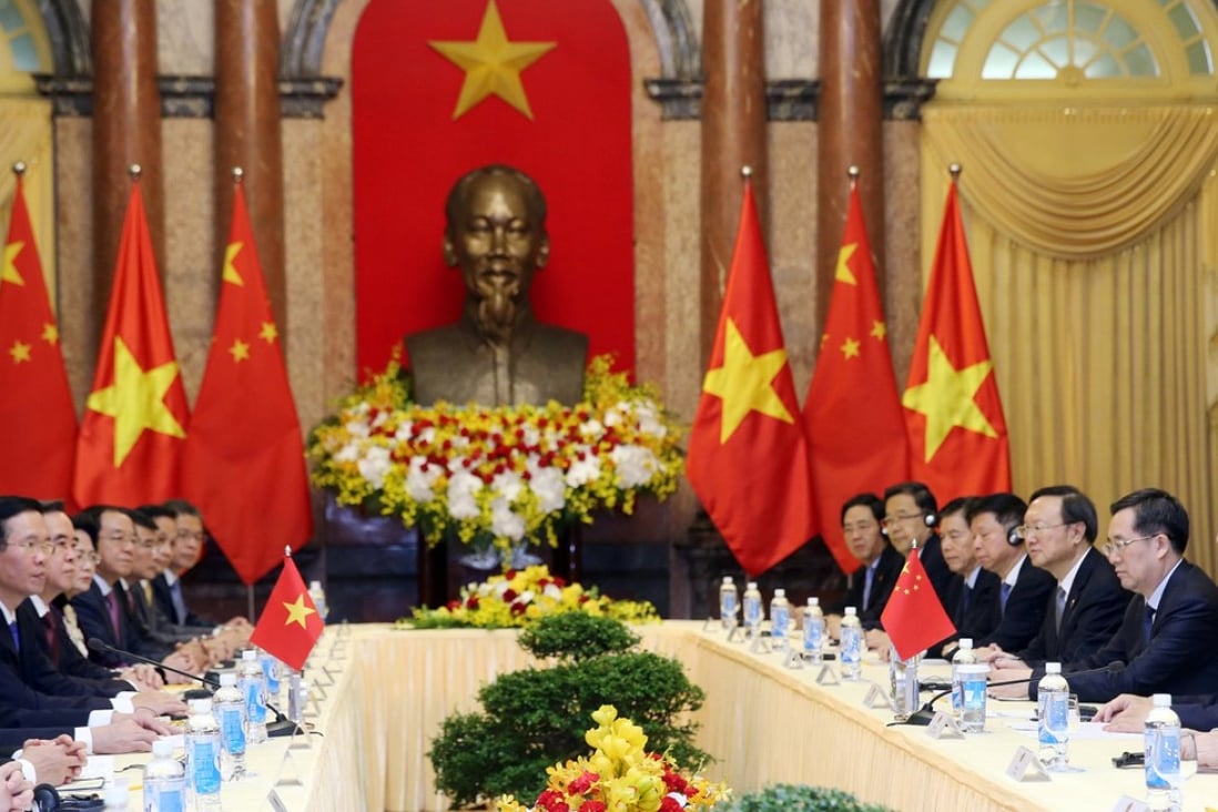 Chinese President Xi Jinping (right) listens as Vietnamese President Tran Dai Quang speaks at the Presidential Palace in Hanoi on Monday. Photo: Reuters
