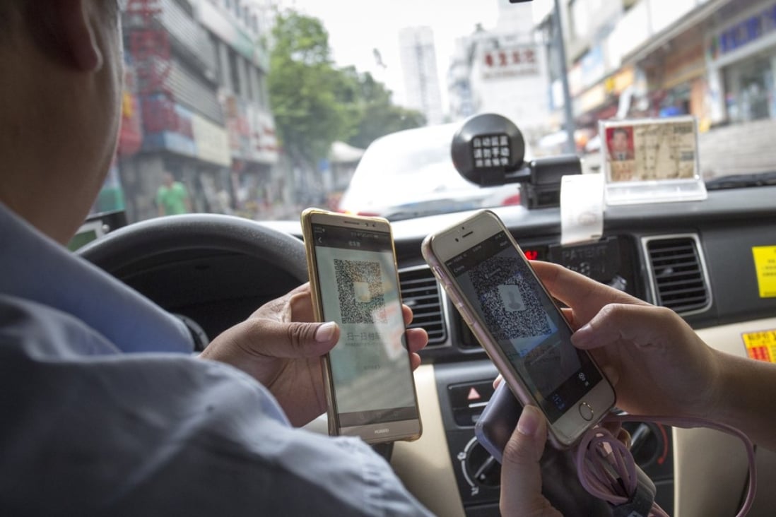A Shenzhen taxi driver accepts fare payment via a mobile app in August. Photo: May Tse
