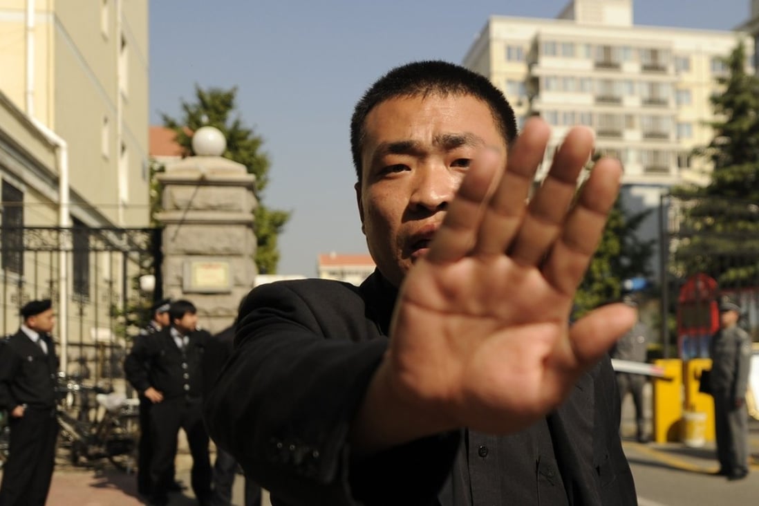 A file picture taken in 2010 of a plain-clothes policeman trying to stop photographs being taken outside the house in Beijing of Liu Xia, the wife of the Chinese Nobel Peace winner Liu Xiaobo. Liu died earlier this year of cancer while serving a jail sentence, but his wife is still under house arrest. She has never been charged with an offence. Photo: AFP