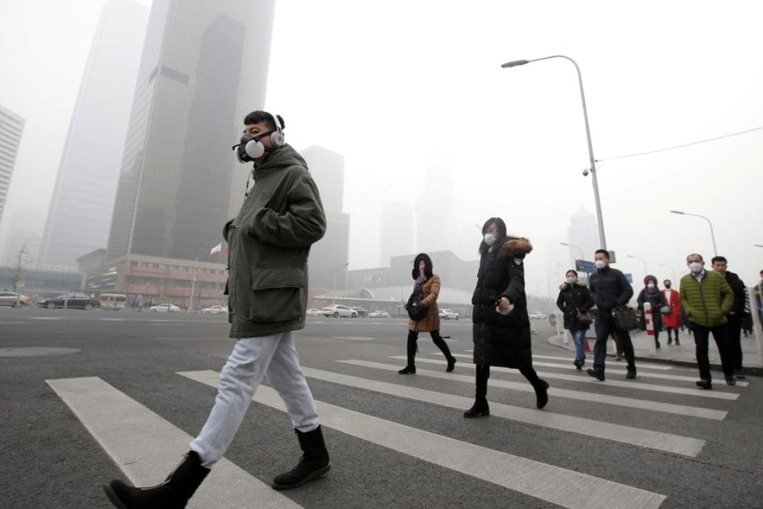 Pedestrians wear masks as thick smog blankets Beijing in December last year. Photo: Reuters