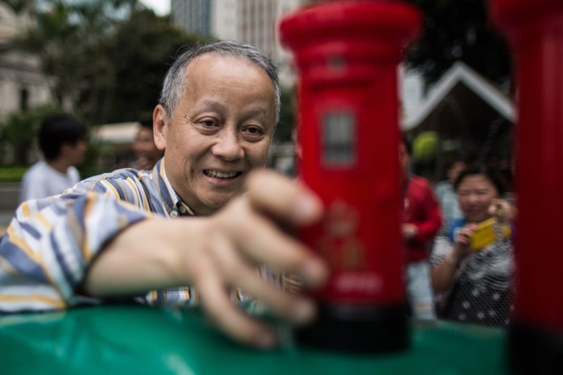 A Hongkonger with a toy colonial-era British mail box souvenir. Photo: AFP