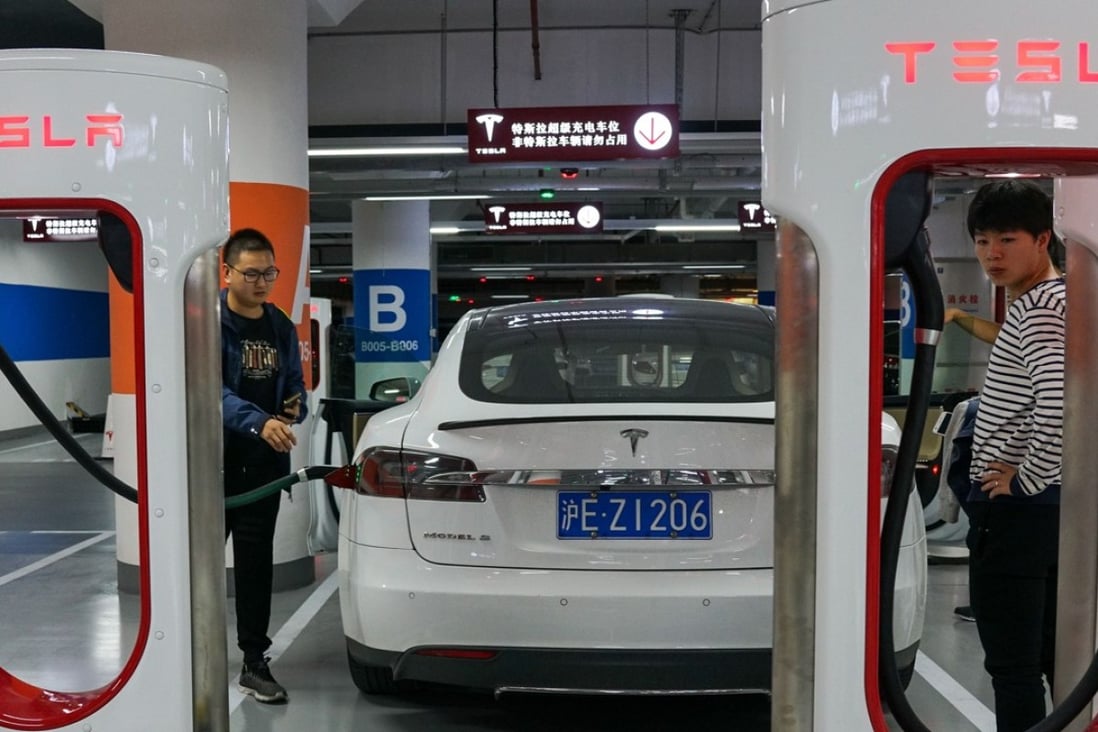 People charge their Tesla vehicles at a charging station inside a mall in Shanghai. Photo: AFP