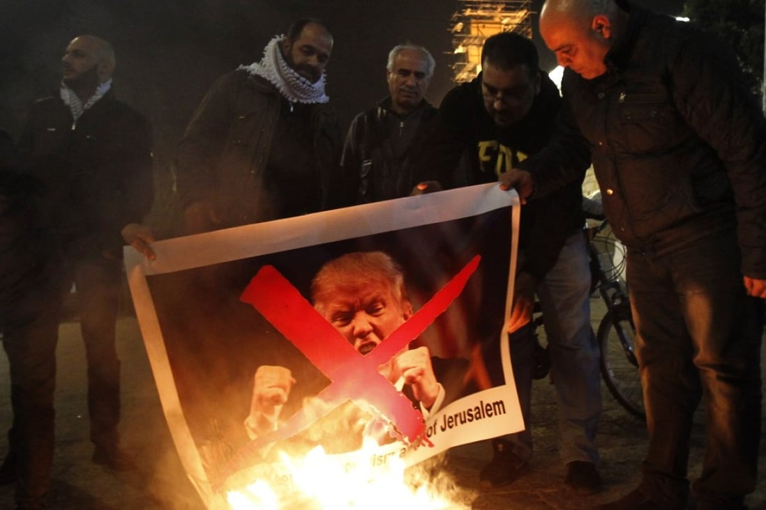 Palestinian protesters burn pictures of US President Donald Trump at the manger square in Bethlehem on December 5, 2017 after Trump announced his plan to recognise Jerusalem as Israel’s capital on Wednesday. Photo: AFP