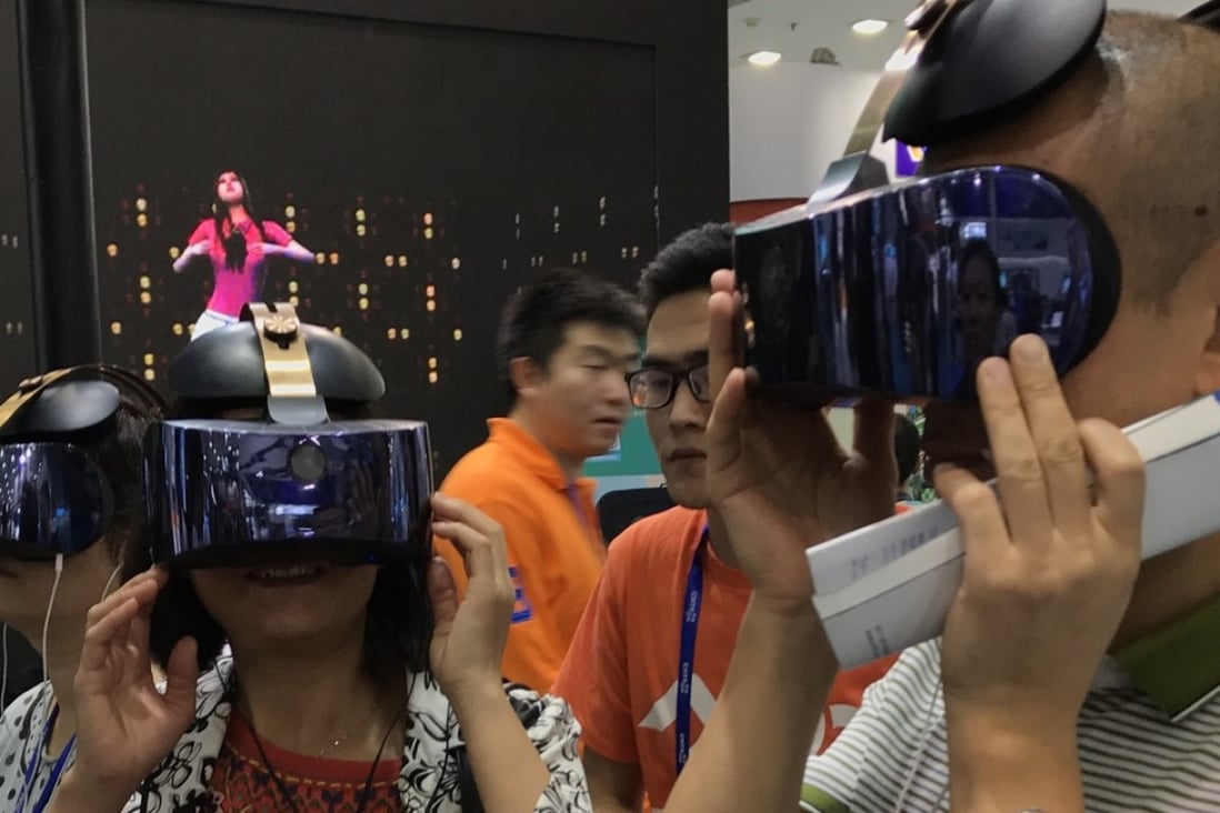Participants at the China Hi-Tech Fair 2017 event, which was held in November in Shenzhen, try out the Qiyu virtual reality headset from iQiyi, the Netflix-style online video-streaming company controlled by Baidu. Photo: Handout