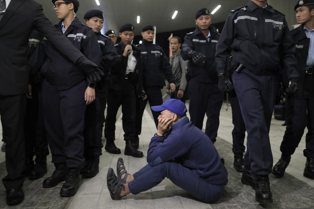 A pro-democracy protester is surrounded by police officers outside the Legislative Council building in Hong Kong, on December 12. Photo: AP