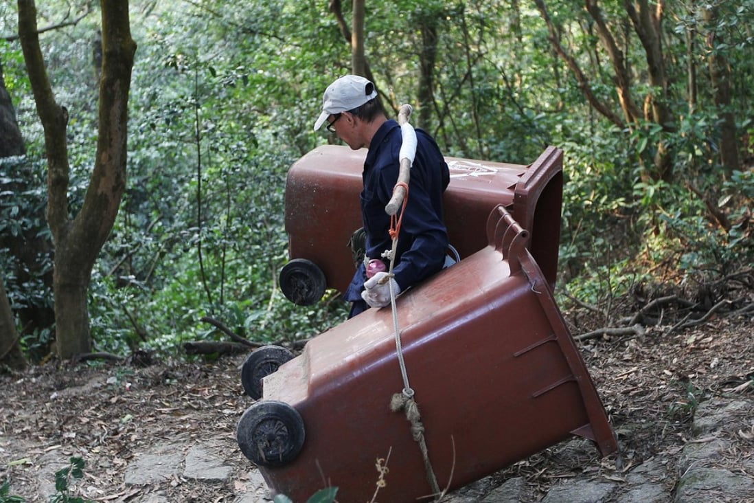 An AFCD Hong Kong worker remove the remaining rubbish bins from trails on Lion Rock Country Park. Photo: Roy Issa