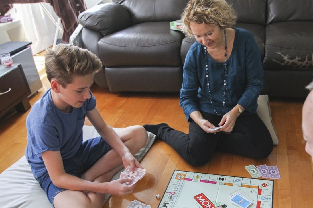 Alison Middleton (centre), a wellness ambassador at Health Nation in Central, enjoys a game of Monopoly with her son Alex and husband, Steve, in the lead-up to Christmas. Photo: Roy Issa