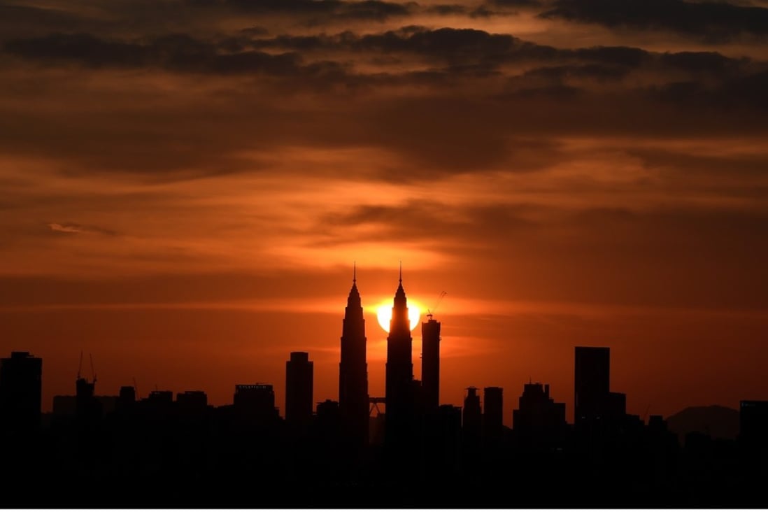 Malaysia's landmark Petronas Twin towers are silhoutted as the sun sets over the Kuala Lumpur skyline. Photo: AFP/MANAN VATSYAYANA