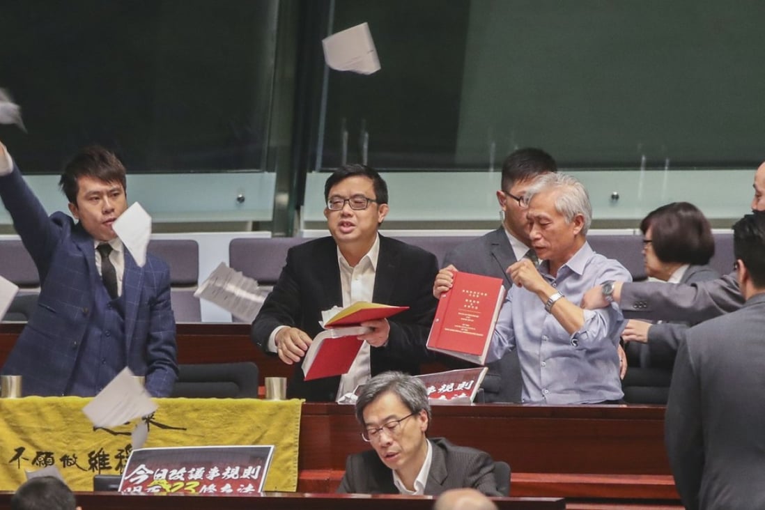 Lawmakers (from left) Roy Kwong Chun-yu and James To Kun-sun of the Democratic Party, and Leung Yiu-chung, tear up the Rules of Procedures and House Rules of the Legislative Council and throw the pages in the air, during a debate on the proposed amendment to the rules of Legco meetings, on December 15. Photo: Edward Wong