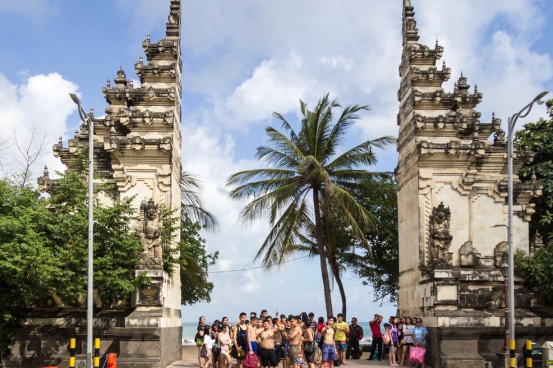 Chinese tourists at the entrance to Kuta Beach in Bali. Photo: Alamy