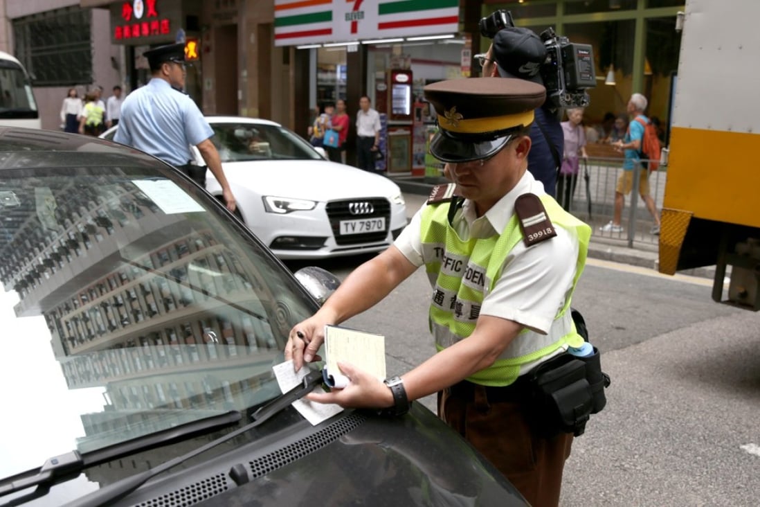 A traffic warden issues a ticket for illegal parking in Tsat Tsz Mui Road in North Point. Photo: Sam Tsang