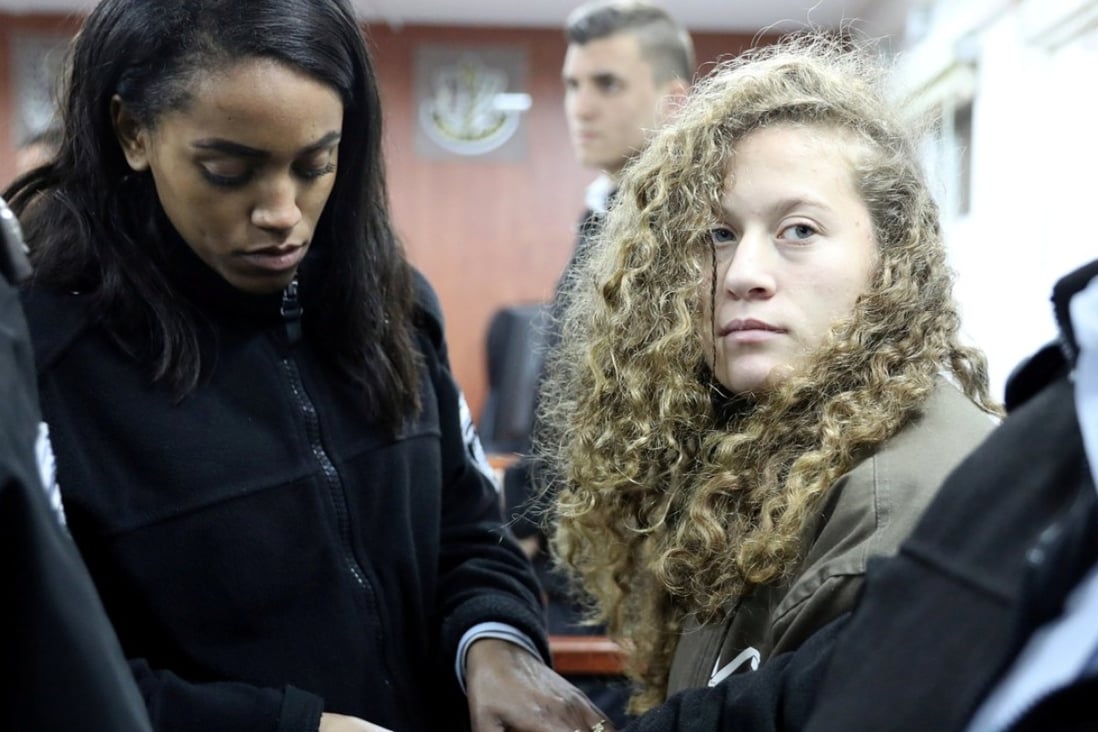 Palestinian teen Ahed Tamimi (R) enters a military courtroom escorted by Israeli Prison Service personnel at Ofer Prison, near the West Bank city of Ramallah. Photo: Reuters