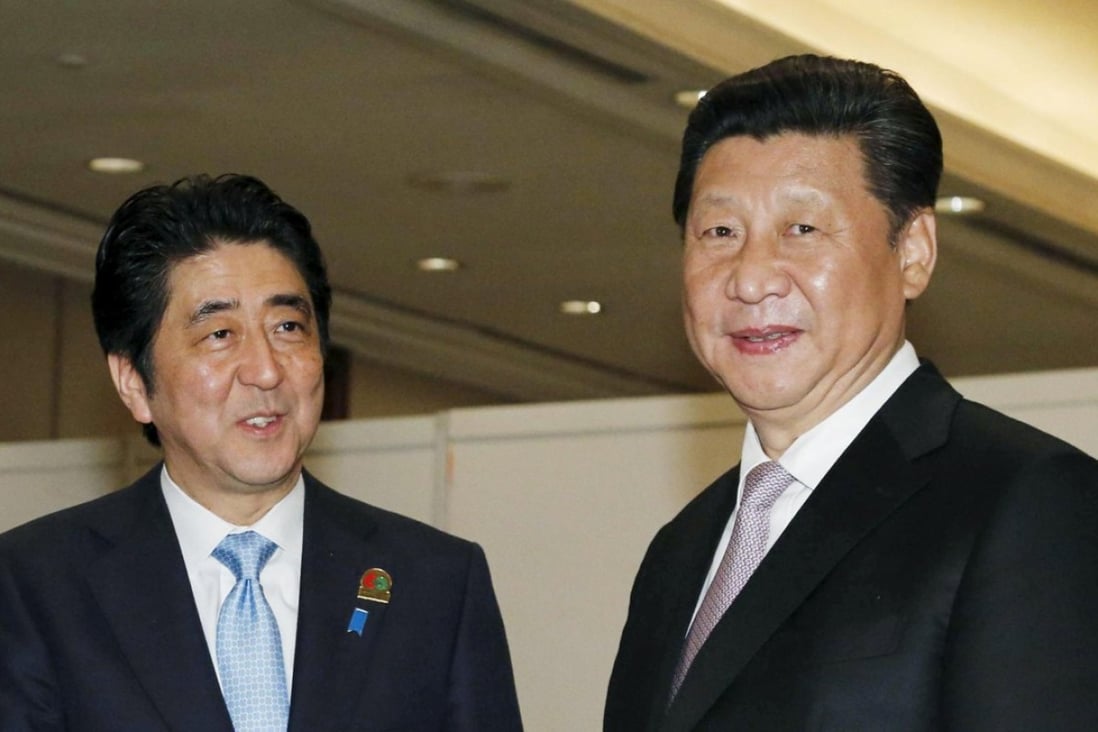 Shinzo Abe with Xi Jinping at the start of their bilateral meeting on the sidelines of the Asian-African Conference in Jakarta. Photo: Reuters