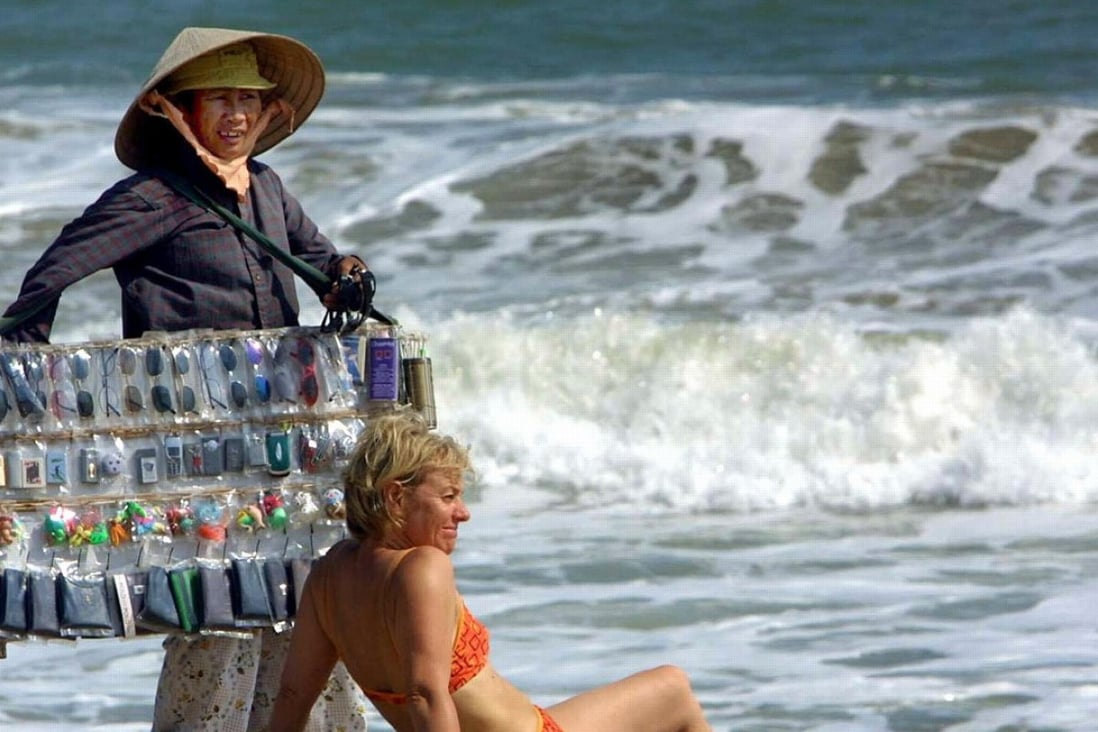 A vendor tries to sell sunglasses to a tourist in Nha Trang, Vietnam. Photo: AFP