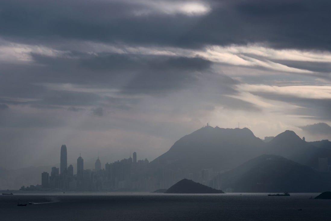 A commuter ferry (bottom R) sails towards Hong Kong Island as light shines through clouds in the skies above on November 25, 2016. Photo: AFP