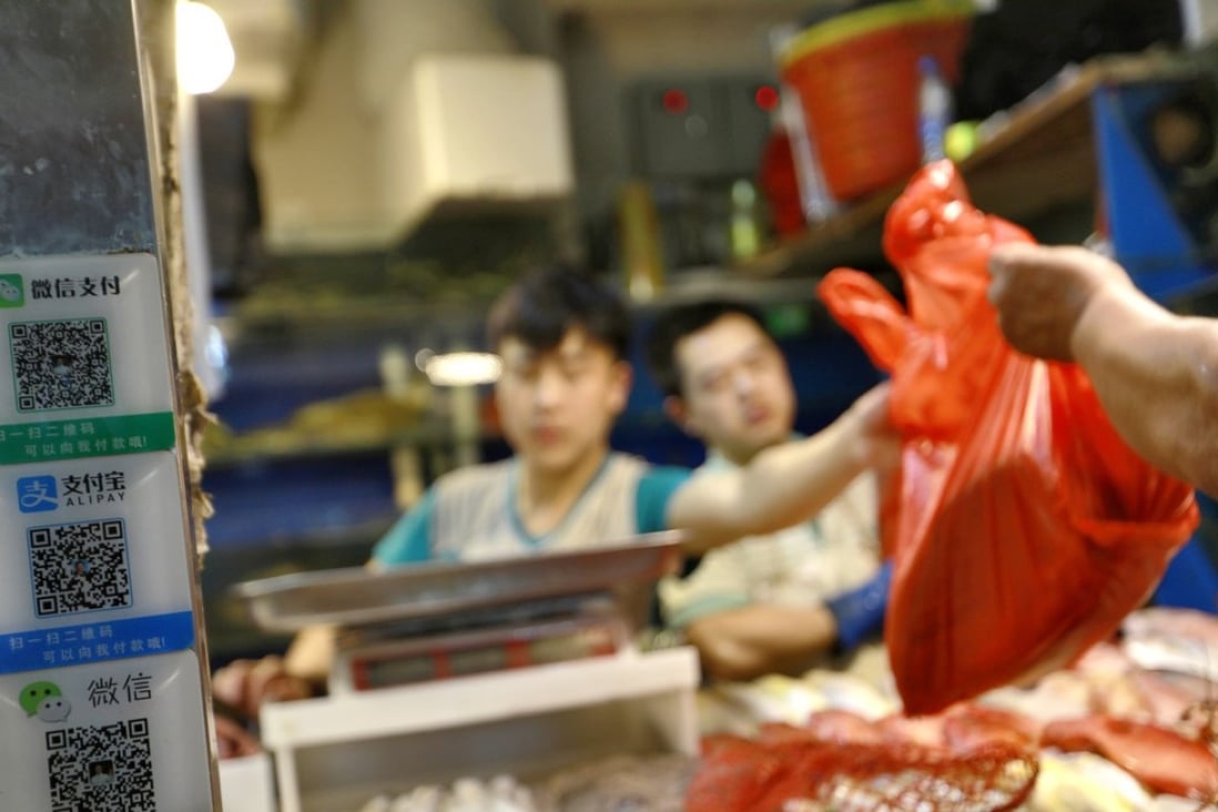 QR codes for mobile payments via Wechat and Alipay are seen on a seafood stall in a market in Beijing. Photo: EPA