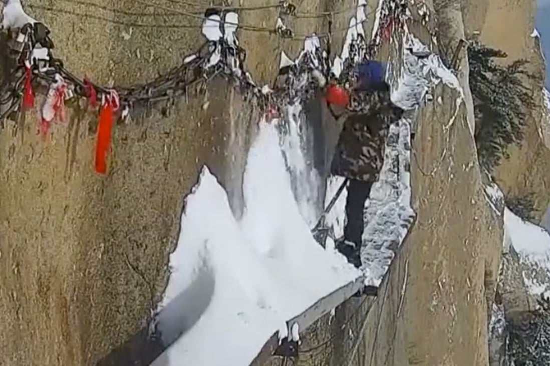 Zhang Dongdong gets to work clearing snow from a narrow pathway on Huashan in northwestern China. Photo: News.163.com