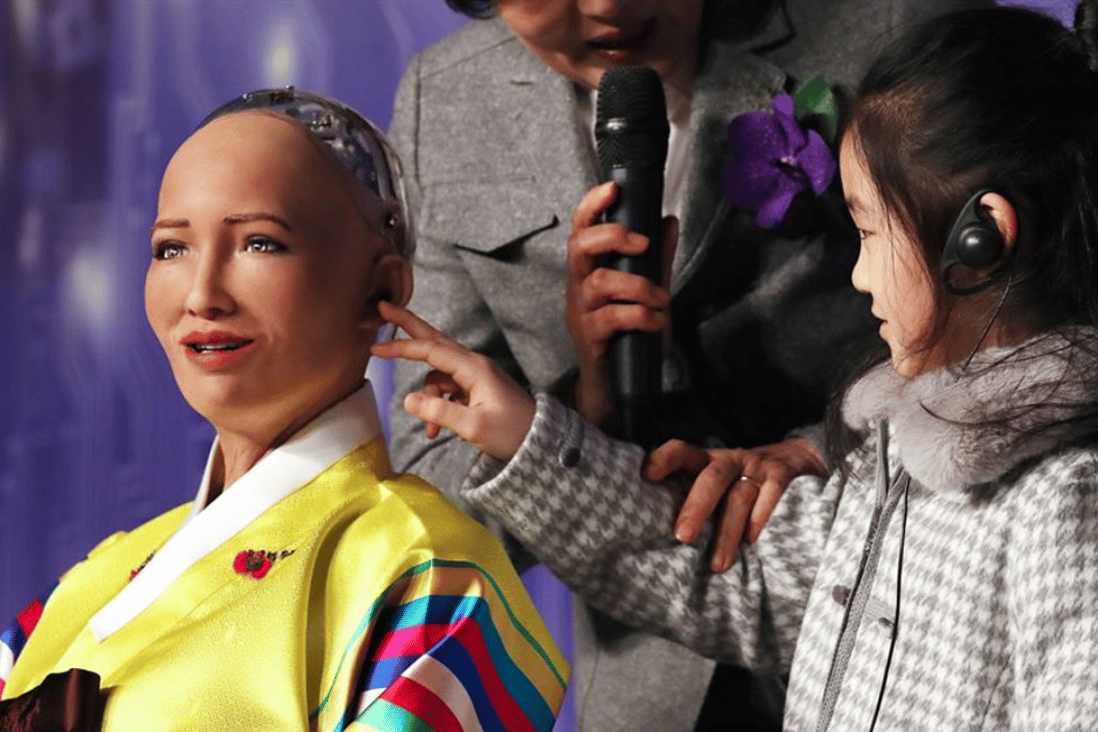 A little girl tries to touch artificial intelligence robot, Sophia, in Korean traditional costume, during a conference on the Fourth Industrial Revolution and AI robots held at the Plaza Hotel in downtown Seoul, Tuesday. Photo: Yonhap