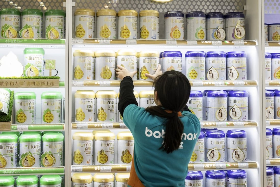 An employee arranges cans of Illuma infant formula, produced by Nestlé, on a shelf at store in Shanghai. Photo: Bloomberg