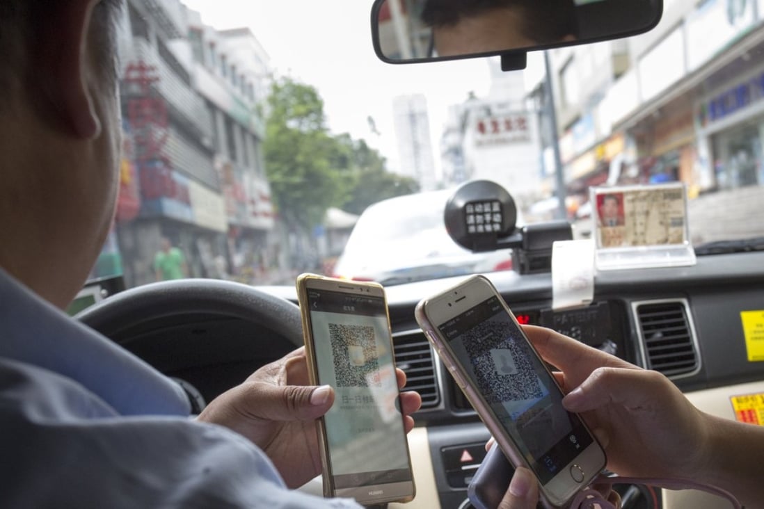 A passenger pays for her taxi ride by mobile payment in Shenzhen, southern China. Chinese consumers spend 50 times more on mobile payments than their American counterparts. Photo: May Tse 