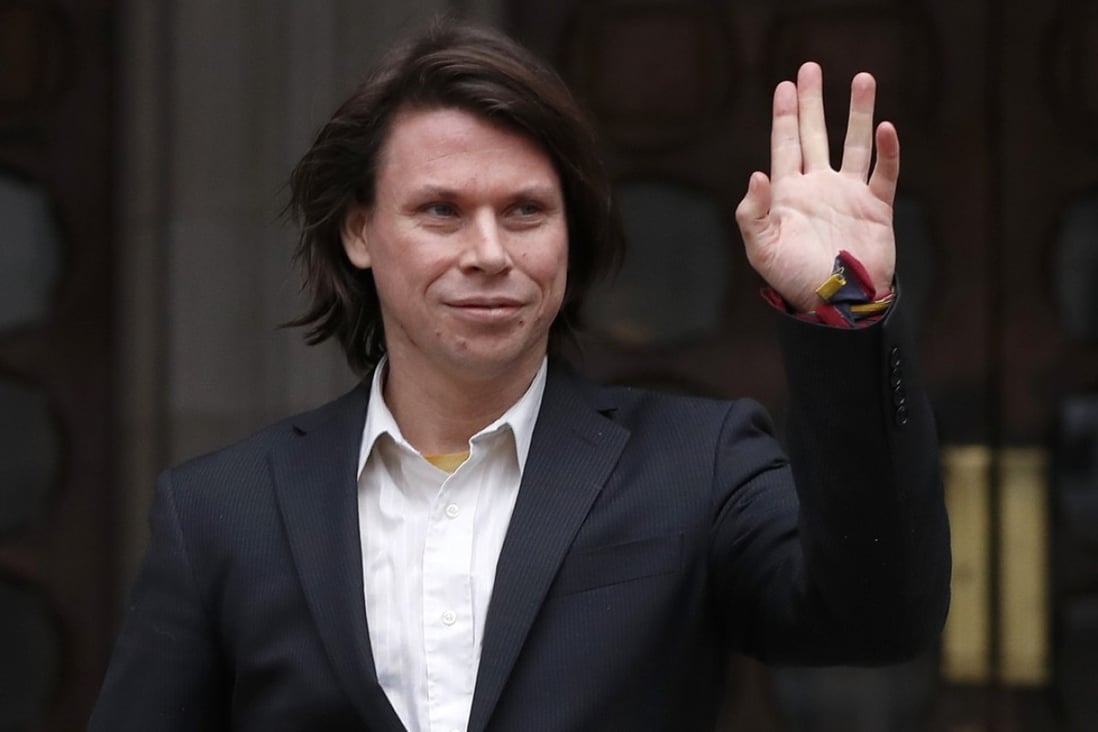 Lauri Love waves to supporters outside The Royal Courts of Justice in London. Photo: AP