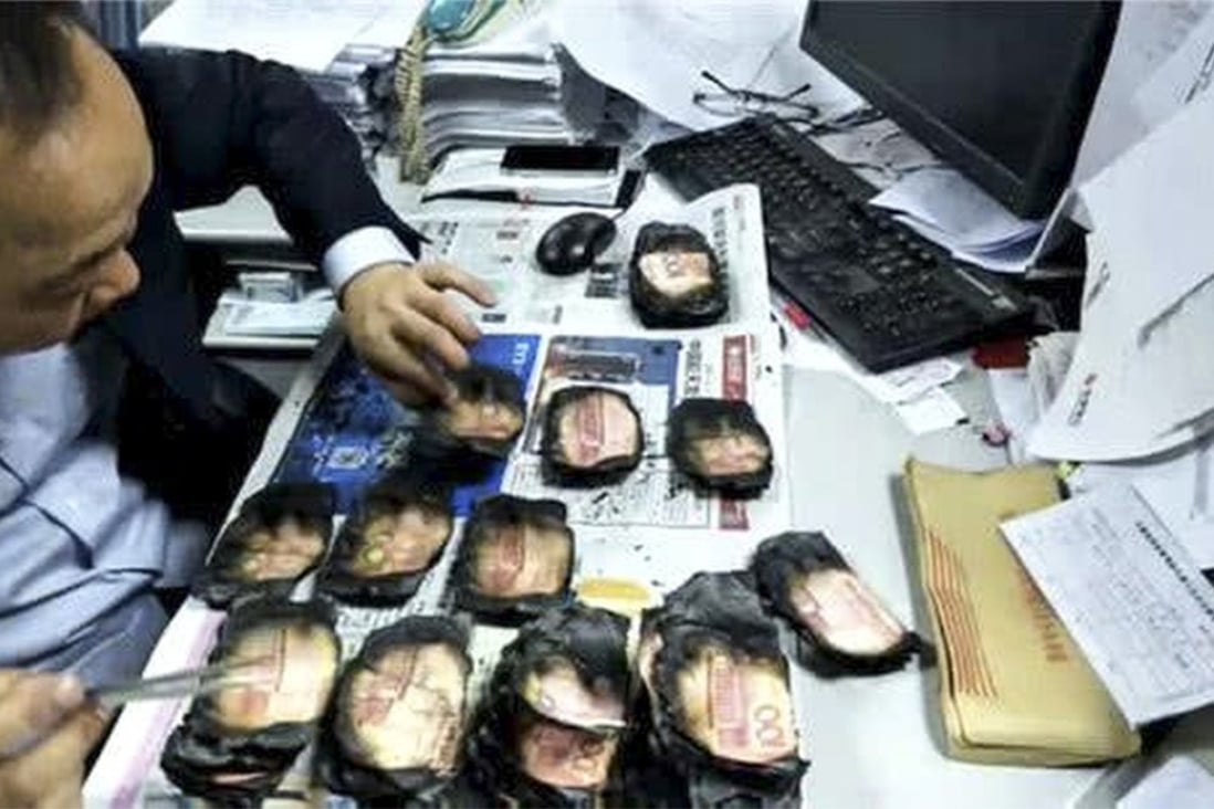 A Bank of Chengdu employee checks some of the badly burnt banknotes. Photo: Thepaper.cn