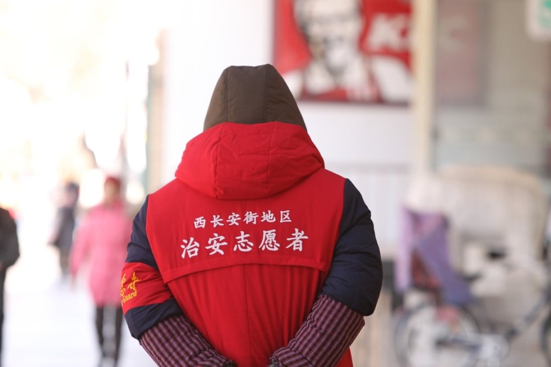 A volunteer security monitor patrols Xidan, one of Beijing’s major shopping district a day after a woman was fatally stabbed. Photo: Simon Song