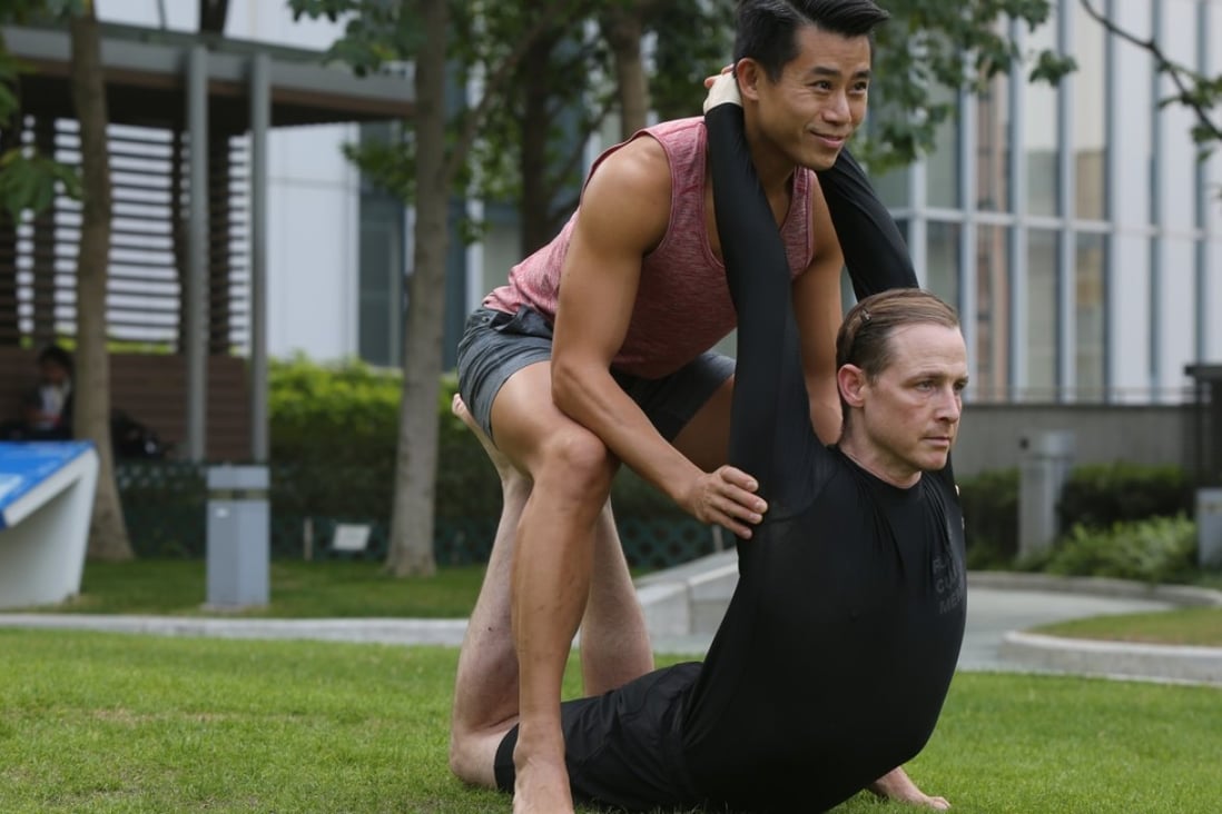 Victor Chau and partner Adam Hawkshaw work out at Tamar Park, Admiralty, in Hong Kong. Photo: Xiaomei Chen