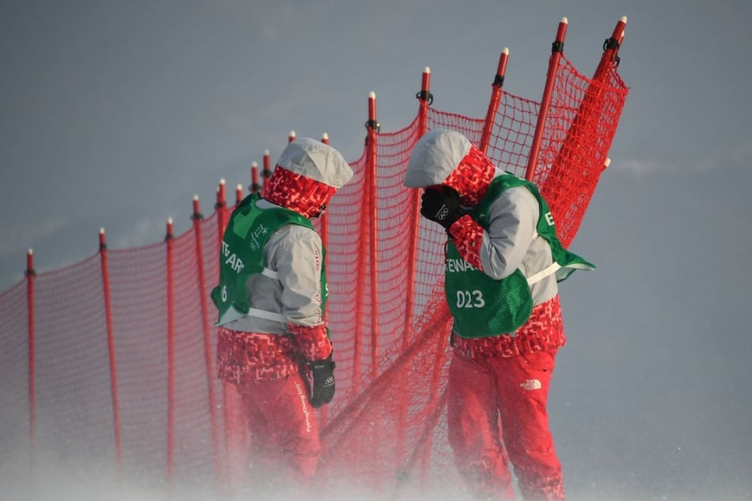 Stewards adjust a net as winds blow after the alpine skiing women’s slalom was cancelled set to weather. Photo: AFP