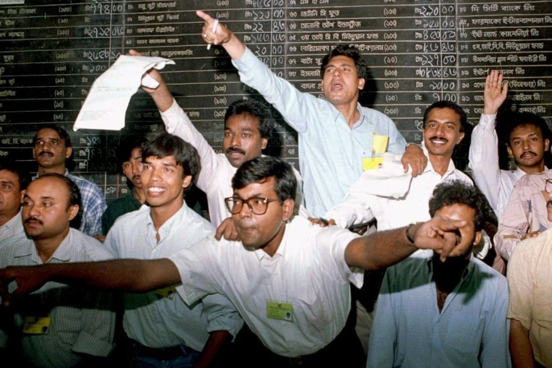 China and India are in a bidding war over teh Dhaka Stock Exchange (DSE). Pictured: Brokers on the floor of the DSE in 1996. File photo: Reuters
